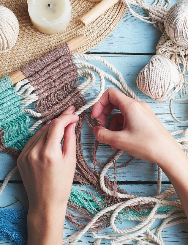 Hobby knitting macrame top view of the hand and thread on a wooden Board