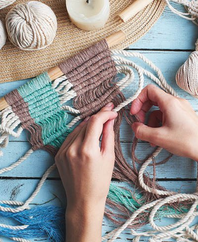 Hobby knitting macrame top view of the hand and thread on a wooden Board