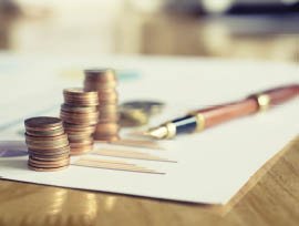 Saving stack coins money concept,graph,chart document and pen on desktop desk in hipster office,copy space.selective focus,vintage color