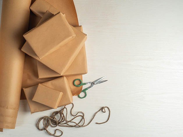 Gift wrapping in craft paper. Packaging process. Preparation.