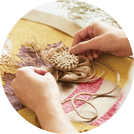 Close-up shot of talented woman sitting at desk and giving final touches on creative decor item